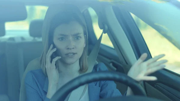 Young angry woman driver talking by phone while driving a car serious sunset sunlight communication adult cellphone female automobile dangerous connection road sitting smartphone texting slow motion