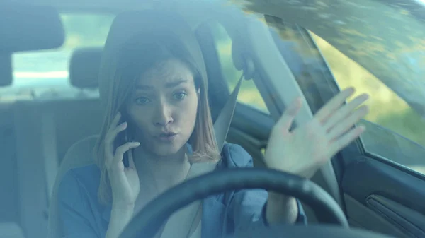Angry young woman driver talking by phone while driving a car serious sunset sunlight communication adult cellphone female automobile dangerous connection road sitting smartphone texting slow motion