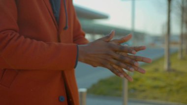 Eller Afro-Amerikan erkek temizleyici sprey serpiyor ve bakteriler COVID-19 Coronavirüs enfeksiyonunu önlüyor. Havaalanı pandemik turizm salgını salgını hastalığı yavaş çekim