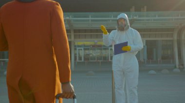 Yolcuların görüntülenmesinin çekildiği Afro-Amerikan adam Covid-19 koronavirüs belirtileri gösteriyor. Uluslararası havaalanı enfeksiyonunu gizleyen koridemik yolcular yavaş çekim altında.