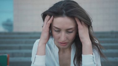 Kriz 2020 afişi. İnsanlar işlerini kaybettiler. Mutsuz esmer, genç iş kadını merdivenlerde oturan iş kaybından endişeleniyor. Salgın. Karantina.