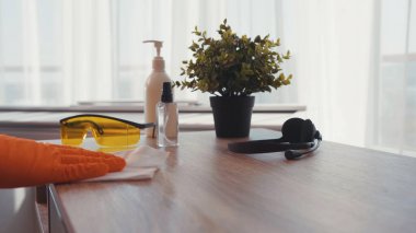 Ağır çekimde adam daireyi sterilize ediyor. Antiseptik spreyle bir masa yüzeyini temizliyor. Evdeki enfeksiyondan evi temizliyor.