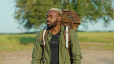 Sırt çantalı gülümseyen Afro-Amerikan genç adam. 3D kimlik tarama bilgileri. Açık hava yüz teknolojisine bakın.