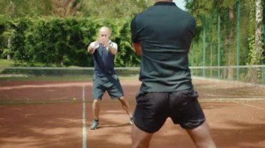 Genç oyuncular tenis maçından önce antrenörle atlamaya hazırlanıyor. Antrenman antrenmanı, egzersiz, spor salonu, spor salonu, spor salonu, yaz, yavaş çekim.