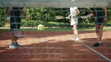 Komik koç tenis oynamayı öğretiyor erkek ve kadın açık hava sporcuları etkinlik oyunu maç spor giyim antrenmanı cevap yaz antrenmanı yavaş çekim eğitmeni