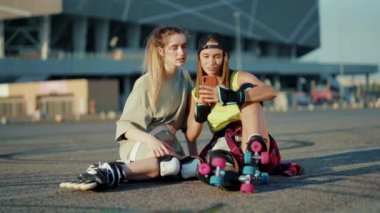 Paten kayan iki genç kadın yaz aylarında gülümseyen telefonlar kullanır. Ayaklar kayar, ağır çekimde hareket eder.