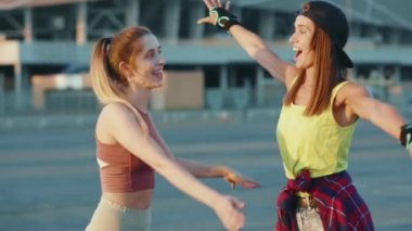 Çekici iki erkek portresi. Birbirlerine sarılmış kameraya bakın. Dışarıda paten kayıyorlar.