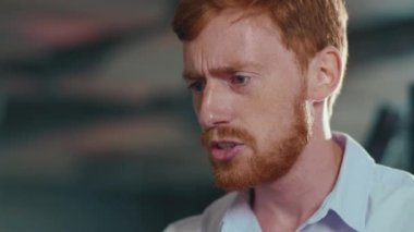 Ciddi kızıl saçlı genç işadamı meslektaşlarıyla iş ortaklığını video sohbet dizüstü bilgisayarlı uzak konferans semineriyle tartışıyor. Yakın çekim..