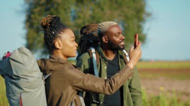 Yakışıklı Afro-Amerikan çift doğal parktaki yaz savanasının panoramik videolarını çekiyor. Aile, Afrika safarisi gezisinin tadını çıkarıp keşfeder..