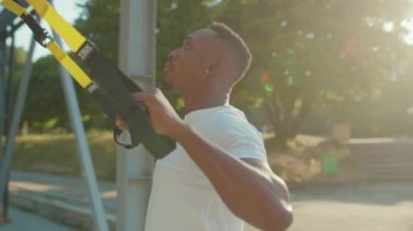 NEW YORK - 5 Eylül 2020: Yüze yakın yakışıklı Afro-Amerikalı adam, güneşli bir günde stadyumda vücut egzersizleri yapıyor.