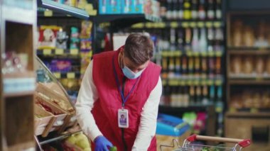 Süpermarkette meyve hokkabazlığı yapan komik, genç satıcı. Güzel, taze, perakende satış mağazası yavaş çekim.