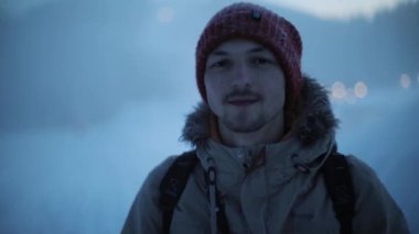 New York, ABD - 5 Mart 2019: Soğuk kış buharında duran genç adamın portresi ve kamera gülüşüne aktif macera teçhizatı keşif ekipmanı kaşifi sis ormanı karını kapatıyor