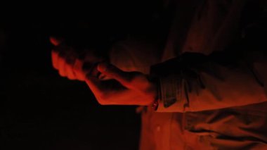 Kapatın genç adam sıcak eller açık bir şömine gece mutlu kış dağları yakacak odun yakacak odun kara doğa sıcak turuncu kamp akşamı eğlence vahşi soğuk yolculuk yavaş hareket
