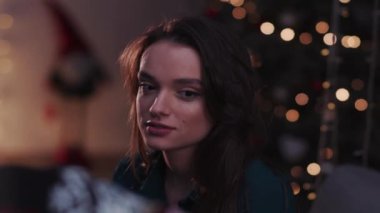 Mutlu genç kadın, Noel ve yeni yıl konseptinde bir Noel hediyesi açıyor. Gülümse. Kutlamaya bak.