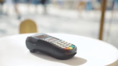 Kafedeki yemek siparişini ödeyen bayan müşteri banka terminaline NFC cep telefonu teknolojisi uygulayarak başarılı ve güvenli bir ödeme yapıyor. NFC ödeme yöntemi.