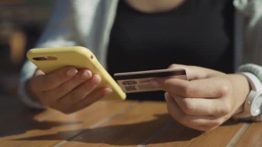 NEW YORK - 15 Haziran 2019: NFC akıllı telefon teknolojisi kullanarak ödeme terminali ile kafede sipariş veren müşteri. Kapalı çekim kız nakit makinesine cep telefonu uyguluyor..