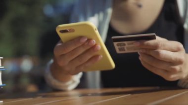 NEW YORK - 15 Haziran 2019: NFC akıllı telefon teknolojisi kullanarak ödeme terminali ile kafede sipariş veren müşteri. Kapalı çekim kız nakit makinesine cep telefonu uyguluyor..