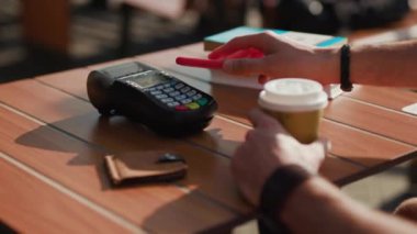 NFC teknolojisiyle ödeme yapan adam, akıllı telefon kartı başvurusu ile Kafe kahve dijital elektronik kablosuz finansal mobil terminal aktarımı yavaş çekim aktarımı