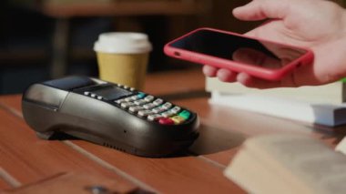 Eller NFC teknolojisiyle ödeme yapıyor. Kafede akıllı telefon kartı başvurusu. Dijital elektronik kablosuz finansal mobil terminal aktarımı.