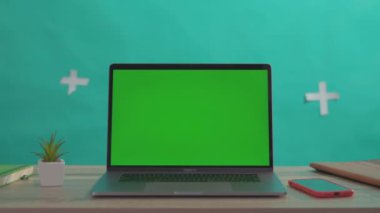 NEW YORK - 5 Nisan 2018: Laptop bilgisayar krom anahtar modeli yeşil ekran, tablet ve akıllı telefon ile yeşil arka planda çalışma alanı. Serbest çalışan işyeri. Yakın plan..