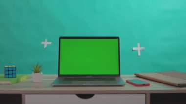 NEW YORK - 5 Nisan 2018: Krom yeşil ekran dizüstü bilgisayarlı akıllı telefon ve tableti yeşil arka planda izole edilmiş ahşap masadaki iş yeri.