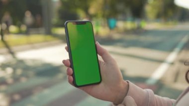 NEW YORK - 5 Nisan 2018: Arka planda internet teknolojisi sektöründe maraton koşan insanların telefonlarına dikey olarak el ele tutuşup, yeşil ekran ile telefona dokunmak yavaş bir iş mesajı