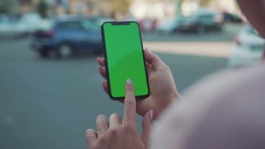 NEW YORK - 5 Nisan 2018: Sokakta internet teknolojisinde yeşil ekranlı telefonu tutan ve dokunan eller iş dünyasındaki mobil metin ağlarına yavaş dokunuyor