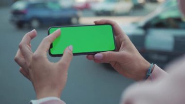 NEW YORK - 5 Nisan 2018: Yavaş çekim kadını, sokak internet teknolojisinde yatay yeşil ekranla el ele tutuşarak ve telefona dokunarak iş dünyasından mobil metin ağlarına dokunuyor