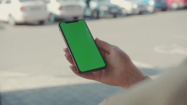 NEW YORK - 19 Mayıs 2019: Gün batımında elinde yeşil ekran daktilo sayfalarıyla dikey telefon kullanan kadın internet teknolojisi akıllı telefon kroma anahtar mesaj cep telefonu yavaş