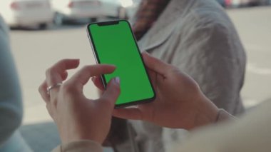NEW YORK - 19 Mayıs 2019: Güneşli bir günde elinde yeşil ekranlı dikey telefonu tutan elleri kapatın insanlar internet teknolojisi akıllı telefon mesajları ile yazı yazarak yürüyorlar