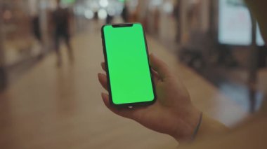 NEW YORK - 19 Mayıs 2019: Alışveriş merkezinin cep telefonu müşteri dijital görüntüleme teknolojisi hipermarket mesajlarını kontrol etmeyi seçen akıllı telefon kullanan genç kadın