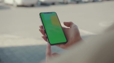 NEW YORK - 19 Mayıs 2019: Güneşli bir günde elinde yeşil ekran ile dikey telefon tutan eller internet teknolojisi akıllı telefon krom anahtar mesaj cep telefonunu araklıyor