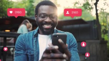NEW YORK - 19 Mayıs 2019: Sırt çantalı gülümseyen Afrikalı Amerikalı adam mutlu vlogger etkisi yaratıcı animasyonu kullanıcı arayüzü - beğeni, takipçiler, akıllı telefondan sosyal medya yorumları yavaş