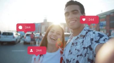 NEW YORK - 19 Mayıs 2019: Mutlu genç çift kamera gülüşüne bakıyor kullanıcı arayüzü ile vlogger etkili animasyon - beğeni, takipçiler, akıllı telefondan sosyal medya yorumları