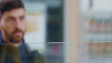 Hasta Kafkasyalı yetişkin bir adam eczanede pencereye yaklaşıp grip belirtileri gösteren öksürüyor. Sağlıksız insanlar. Sağlık, ilaç ve virüs enfeksiyonları.