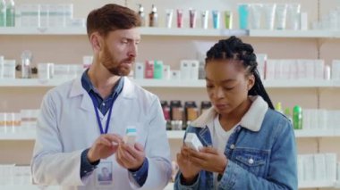 Afro-Amerikalı genç bir kadın ve eczanede danışmanlık yapıyor. Kadın hasta ev içi tedavi için tavsiye istiyor. İlaç konsepti.