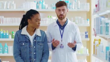 Eczanede sağlıklı güzellik ürünleri gösteren Afro-Amerikan kadın hastalara danışmanlık yapan bir sağlık uzmanı. Sağlık hizmetleri. Eczane.