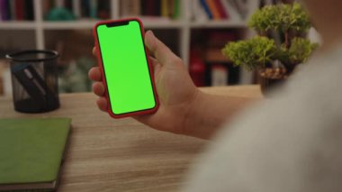 NEW YORK - 19 Mayıs 2019: Kapat genç adam cep telefonunu ofis masasında yeşil ekranlı kullanıyor gündelik boş teknoloji dijital mobil akıllı telefonu internet üzerinden kullanıyor