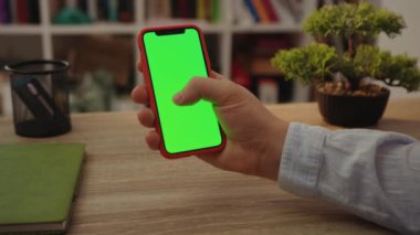 NEW YORK - 19 Mayıs 2019: Genç adam internet dokunmatik ekranını kullanarak yeşil ekranlı cep telefonu kullanıyor.