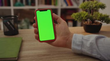 NEW YORK - 19 Mayıs 2019: Genç adam internet dokunmatik ekranını kullanarak yeşil ekran masalı cep telefonunu günlük boş dijital cep telefonu ile kullanıyor.