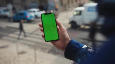 NEW YORK - 19 Mayıs 2019: Yavaş çekim adamı dikey yeşil ekran arka plan araba şehrine sahip telefon kullanıyor internet krom açık hava cep telefonlu akıllı telefon dinleme iletişimini bulanıklaştırıyor