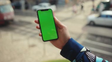 NEW YORK - 19 Mayıs 2019: Dikey yeşil ekran arka plan tramvayı olan telefonu kullanan genç adamı kapat internet krom açık hava cep telefonu akıllı telefonları yavaş dinleme iletişimi