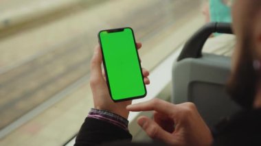 NEW YORK - 19 Mayıs 2019: Genç bir adam, tramvay krom anahtar akıllı telefon teknolojisi cep telefonu telefon mesajı görüntüleme ekranında dikey yeşil ekranlı bir cep telefonu kullanıyor