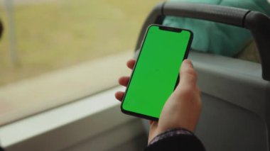 NEW YORK - 19 Mayıs 2019: Genç bir adam, tramvay krom anahtar akıllı telefon teknolojisi cep telefonu telefon mesajı görüntüleme ekranında dikey yeşil ekranlı bir cep telefonu kullanıyor