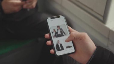 NEW YORK - 19 Mayıs 2019: Hands man, akıllı telefon kaydırmalı resimlerde Clothers uygulaması kullanarak cep telefonu kullanıyor. Fotoğraflar uygulamalı telefon tuşlu akıllı telefon teknolojisi ile iletişim mesajı görüntülemesini seçin
