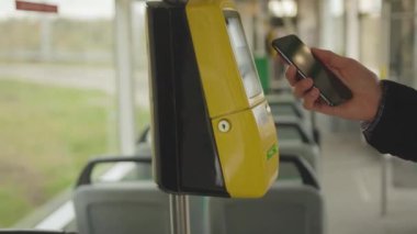 NEW YORK - 19 Mayıs 2019: Genç bir adam tramvay arka planında cep telefonu satın almak için telefon kartı kullanıyor.
