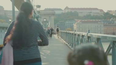 Budapeşte, Macaristan - 19 Mayıs 2019: Birçok insan köprüde yürüyor kentsel enerji erkek mimarisi bisikletli yetişkin siluetleri şehir bisikletçileri sokak, modern iş binaları yavaş iş trafiği ortamı