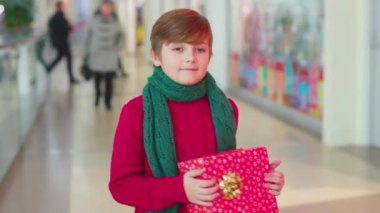 Mutlu çocuk alışveriş merkezinde yürüyor Noel hediyesi kutularına koyuyor çocuk ailesi çekici genç çocuklar neşeli mutlu tatil çocuğu yavaş çekimde gülümsüyor