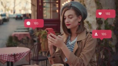 Kafe kahvaltısında oturan kırmızı rujlu şık genç bir kadın yorum yapan takipçi sayacı gibi sosyal medya simgelerini kullanın. Etkilendirici blog portresi dışarıda ağır çekimde.