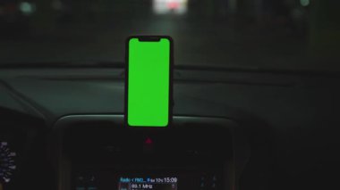 NEW YORK - 5 Nisan 2019: Hands man, konsolda yeşil ekran ekranlı araba akıllı telefonu kullanıyor.